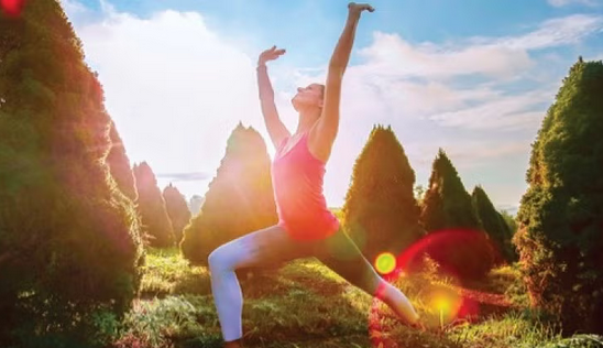 femme pratiquant du yoga, guerrier III, devant un magnifique lever du soleil printanière en haut d'un montagne
